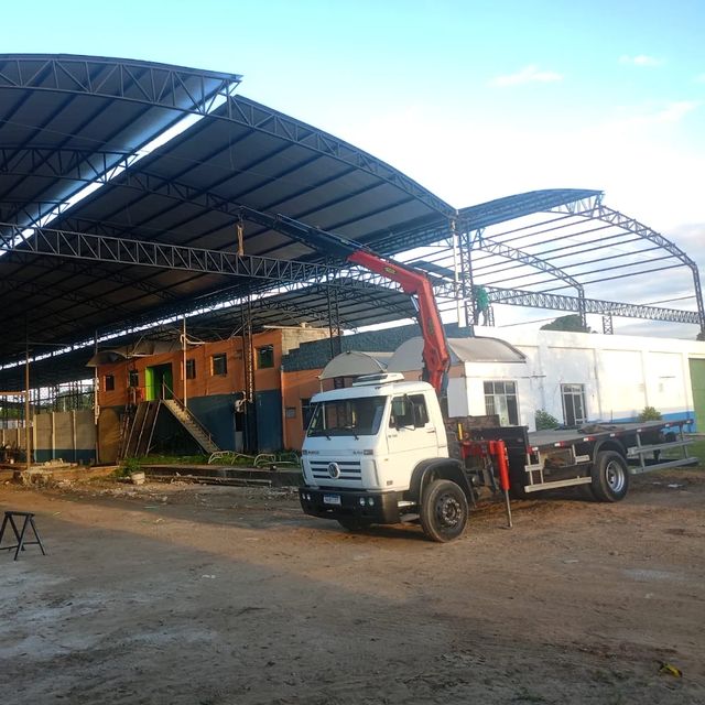 Caminhão munck em obra de montagem de galpão com cobertura metálica